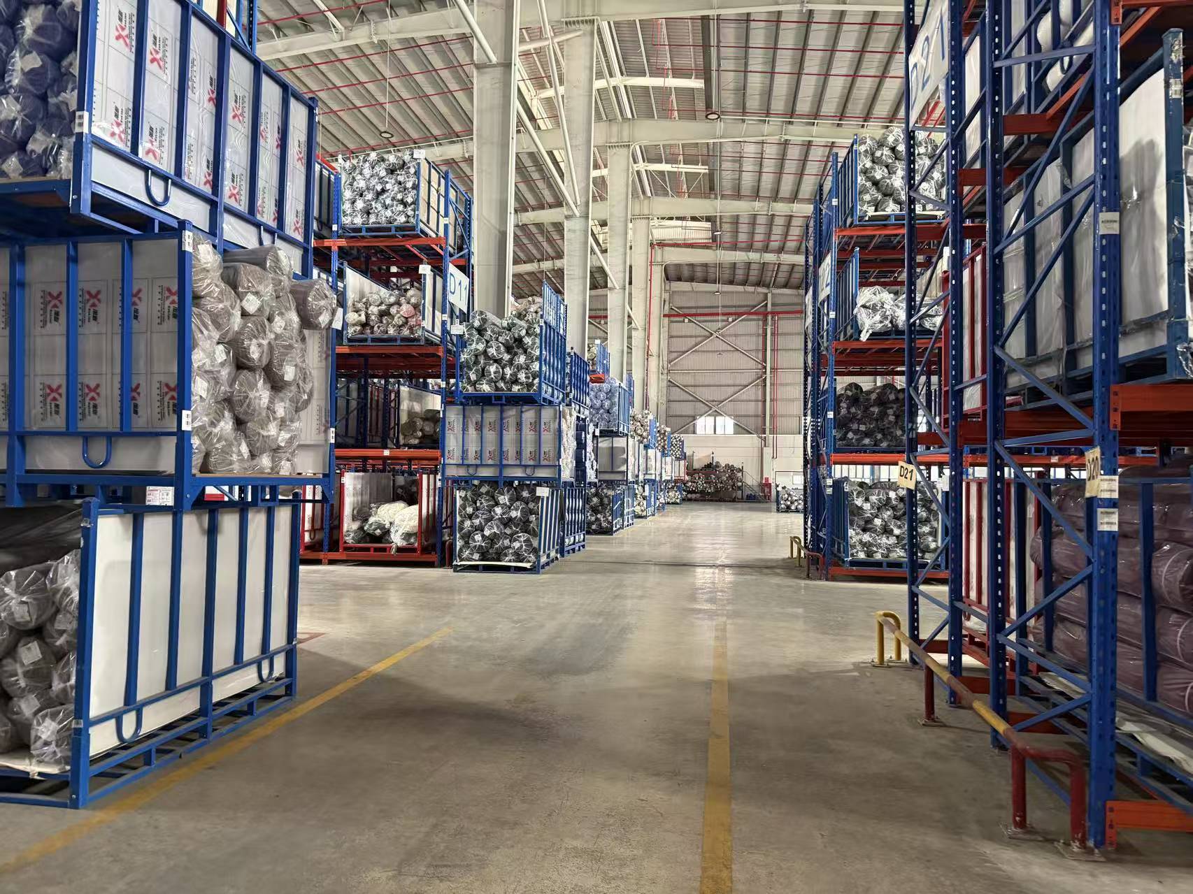 Warehouse racking stacked with bagged finished fabric inventory, ready for export.