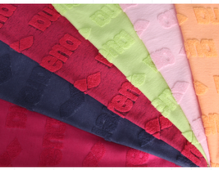 Fan of embossed jacquard swatches with a repeating branded relief.